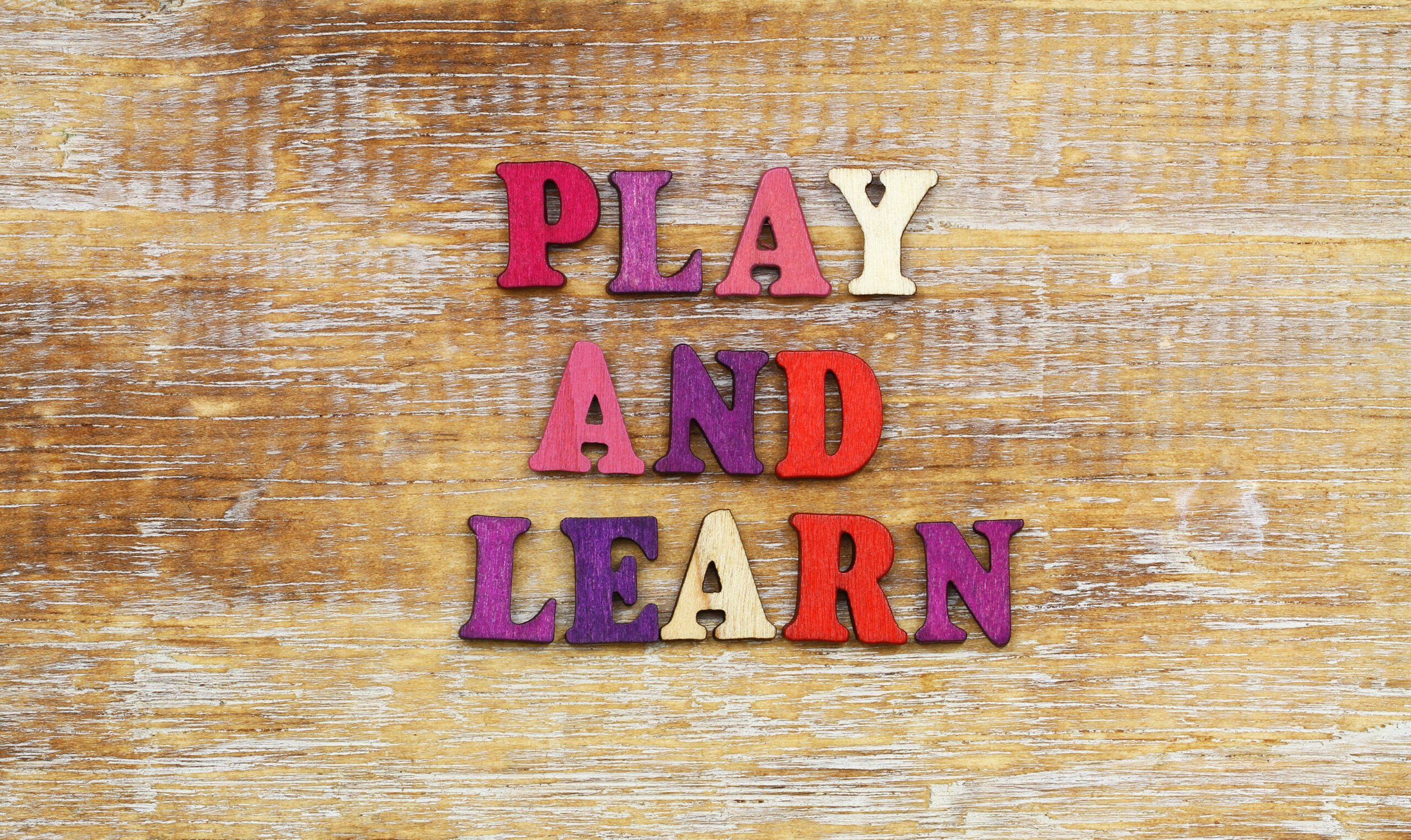 Play,And,Learn,Sign,Written,With,Colorful,Wooden,Letters,On
